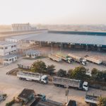 An aerial shot of factory trucks parked near the warehouse at daytime